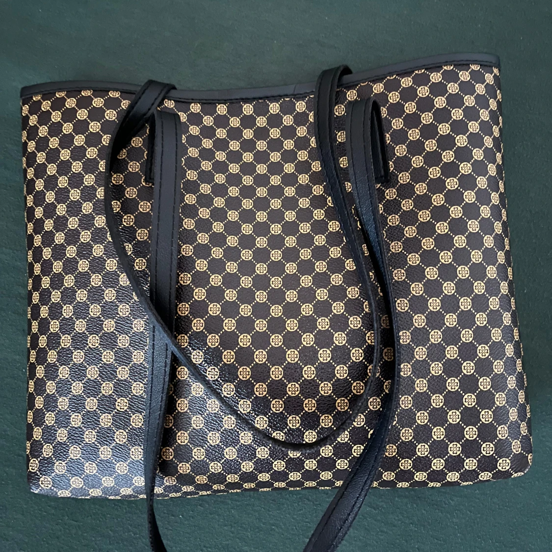 Svart och guldmönstrad axelväska