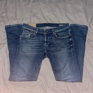 Blå skinny jeans från Dondup Ritchie - Säljer ett par blå jeans från Dondup, modell Ritchie Skinny Fit. Snygga slitningar och Passformen är tight och de är tillverkade i mjukt denim-material. Perfekta för dig som gillar en smal siluett. Storleken är 50 | W34. 