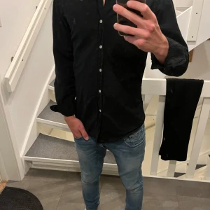 Svart skjorta från Ralph Lauren - Säljer en svart skjorta från Ralph Lauren med lila logga. Det är slimfit. Säljer den då den it kommit till så mke användning. 