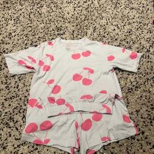 Ljusblått Pyjamas sett med rosa körsbär 🍒  - Superfina ljusblåa shorts med elastisk midja och ett supergulligt rosa körsbärsmönster. Perfekta för att chilla och ha som mysplagg hemma. Mjukt bomullsmaterial som känns skönt mot huden gör inte så att man får en sån där obehaglig varm känsla, har en liten grå fläck (kan ses på sista bilden) men inget man tänker på när man har på sig dem💙