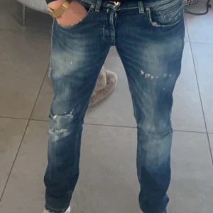Dondup George stl 30 - Säljer ett par Dondup George jeans i mörkblå tvätt med coola slitningar och detaljer. Modellen är slim och har klassiska fem fickor, dragkedja och knapp. Perfekt för dig som gillar en streetig och avslappnad stil.