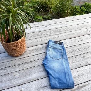 Calvin Klein Slim Taper jeans blå - Snygga ljusblå jeans från Calvin Klein med slim taper passform. Klassisk femficksmodell med CK-detalj på fickan och svart logopatch bak i midjan. Inköpta för 1400 säljer för 449kr men ej hugget i steg😊😊