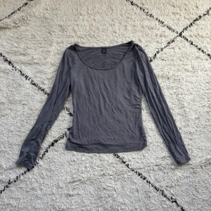 Grå långärmad topp från SHEIN - En basic grå långärmad topp från SHEIN i storlek XS Petite. Modellen är figurnära med rundad halsringning och tillverkad i mjukt bomullsliknande material. Perfekt att styla med jeans eller kjol för en clean look.