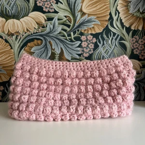 Rosa stickad clutch/necessär - Rosa fluffig clutch/necessär som är perfekt nu till höstens alla tillfällen. Längd 28cm, höjd 13 cm, djup 5 cm vilket gör att den är rymligare än vad man kan tro. Skriv gärna till mig om du har frågor eller ett prisförslag💕Jag har gjort den själv