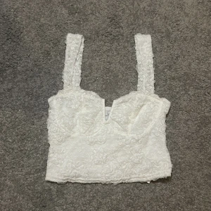 Vit topp - Snygg vit top från Amisu. Som det står på lappen så är den köpt för 159kr men jag säljer den för ett mycket lägre pris. Helt använd.