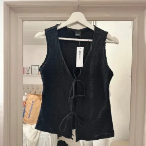 Väst/tröja - Svart väst med knytning från Gina tricot med prislappen kvar!