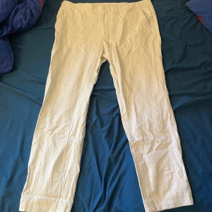 Vita linnebyxor från Riley - Snygga vita linnebyxor från Riley med regular fit. Byxorna har rak passform, dragkedja och knapp framtill samt resår i midjan för extra komfort. Perfekta för en chill och stilren look under varmare dagar. Använda max 3-5 gånger. 