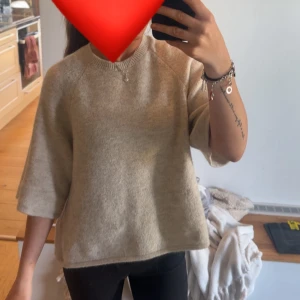 Beige stickad tröja med trekvartsärm - Säljer en beige stickad tröja med rund hals och trekvartsärmar. Tröjan har en loose passform och är supermjuk, perfekt för chill dagar. Enkel och stilren design som funkar till allt. Materialet känns varmt och skönt mot huden.