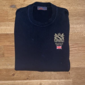 Svart stickad tröja från Morris - Stickad Morris tröja i väldigt fint skick. Tröjan har inga som helst defekter förutom att taggen kanske är lite sliten. Passar väldigt fint till hösten och speciellt till vintern då den är väldigt varm och enligt mig väldigt skön att ha på sig. Tröjan är svart men pågrund av blixten på kameran ser den lite mörkblå ut.