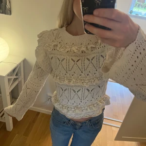 Vit stickad volangtröja från Zara - Superfin kräm vit/beige stickad tröja från Zara med volanger och spetsdetaljer. Tröjan har ett genombrutet mönster, rund halsringning och långa ärmar. Använd en hel del men ändå i bra skick! 