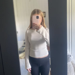 Vit långärmad topp från Kappahl - Säljer en enkel och fräsch vit långärmad topp från Kappahl. Modellen är slim och har en rundad halsringning. Materialet är mjukt och stretchigt, perfekt att matcha med jeans eller kjol. Toppen är stilren och passar dig som gillar minimalistisk look.