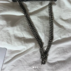 Svart quiltad axelväska Kurt Geiger - Snygg svart axelväska från Kurt Geiger med quiltad design och grov silverfärgad kedjerem. Väskan är i skinnimitation och har ett stilrent innerfoder med logotyp. Perfekt för dig som vill ha en trendig och tidlös accessoar.