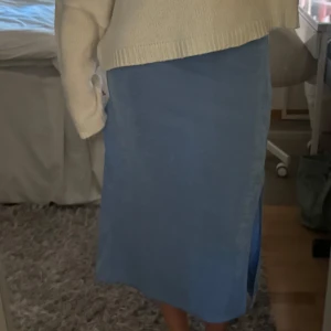 Blå midikjol - Blå midikjol med slits, tyget är skimrigt och lite genomskinligt