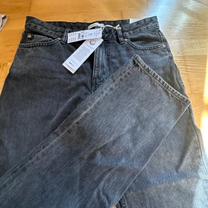 Svarta low straight jeans Gina Tricot - Snygga svarta jeans från Gina Tricot i modellen low straight. Jeansen har låg midja, raka ben och klassisk femficksdesign. Tillverkade i bomull med en cool tvättad finish. Perfekta för en avslappnad och trendig look.