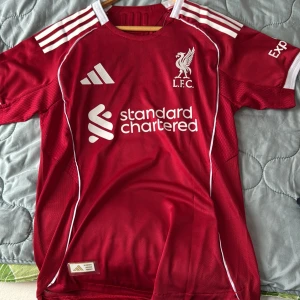 Liverpool röd matchtröja Adidas Wirtz 7 - Liverpool FCs officiella matchtröja från Adidas i röd färg med vita detaljer och tryck. Den är player version 