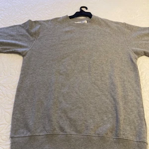 Grå basic sweatshirt i bomull - Enkel och stilren grå sweatshirt från Blend. Tröjan har rund halsringning, långa ärmar och ribbade muddar vid ärmslut och nederkant. Perfekt för en chill och avslappnad look. Tillverkad i mjuk bomull för extra komfort.