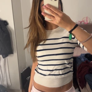 Randig vit tröja med marinblå ränder - Superfin vit tröja från Zara med marinblå horisontella ränder. Tröjan har rund halsringning och korta ärmar, perfekt för vår och sommar. Mjuk och skön i bomullsmix, sitter snyggt och har en klassisk, fräsch look. Priset kan diskuteras 