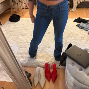 Blå bootcut jeans från Lee - Snygga blå jeans från Lee med klassisk bootcut-passform och normal midja. Jeansen har fem fickor, gul kontrastsöm och Lee-logga på bakfickan samt läderpatch i midjan. 🩷
