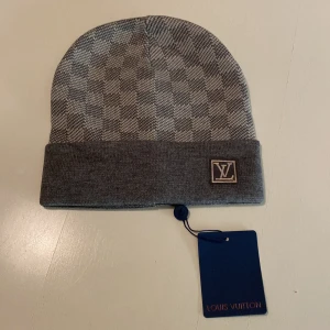 LV mössa - Snygg grå mössa från Louis Vuitton med klassiskt rutigt mönster och uppvikt kant. Bra kvalité 