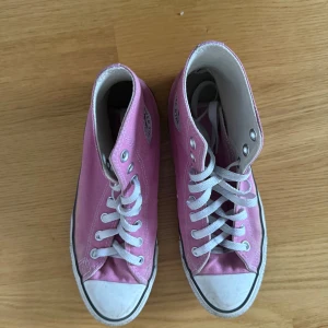 Rosa Converse All Star high tops - Säljer ett par klassiska Converse All Star high tops i ljusrosa canvas med vita snören och rund tå. Skorna är använda men skyddats bra och är i gott skick!!
