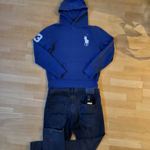 Ralph Lauren hoddie big ponny S - Snygg blå hoodie från Polo Ralph Lauren med stor vit logga på bröstet och siffra på ärmen. Klassisk känguruficka och huva. Tillverkad i en mix av bomull och polyester för skön känsla. Perfekt för dig som gillar stilren streetwear. Storleken är M men skulle säga att den passar bättre på S. Passar nu perfekt inför hösten och vid en snabb och smidig affär kan priset diskuteras. Om du även får några frågor är det bara att höra av sig🫡