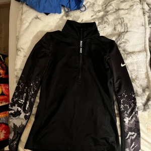 3 pack med träningskläder. Shorts, lång tröja och en kortare Magtröja.  - Säljer ett par svarta shorts med snyggt blommönster i beige och grå toner. De har en bred, svart midjeresår som sitter skönt och ger en modern look. Perfekta för dig som vill sticka ut med ett coolt mönster och bekväm passform.