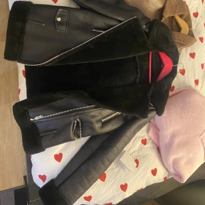 Svart pälsjacka med dragkedjor - Säljer en svart pälsjacka med coola silvriga dragkedjor och bred krage. Jackan har mjukt foder och detaljer i skinnimitation, perfekt för kalla dagar. Snygg och trendig modell som passar till det mesta. Jätte varm jacka köpt från Zara för några år sedan men fortfarande i super bra skick! 