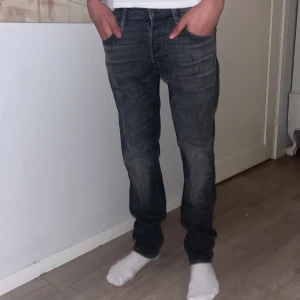 Slim straight jeans i mörkgrå denim - Slim straight jeans från Jack & Jones i mörkgrå tvättad denim. Klassisk femficksmodell med raka ben och normal passform. Snygga slitningar och detaljer, perfekt för dig som gillar en stilren look. Storlek 29/32. Modellen är 182. 