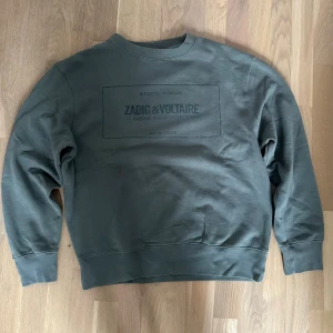 Zadig & Voltaire tröja - Snygg grön sweatshirt från Zadig & Voltaire med tryckt logga framtill. Tröjan har rund halsringning, långa ärmar och ribbade muddar. Perfekt för en avslappnad och trendig look. Mjuk insida och klassisk passform.