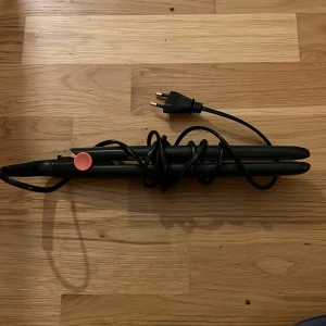 Plattång / Hårplattare - Svart plattång med sladd och EU-kontakt. Är i gott skick utan synliga repor eller skador. Perfekt för att styla och platta håret snabbt och enkelt. Enkel att använda och värms upp snabbt.
