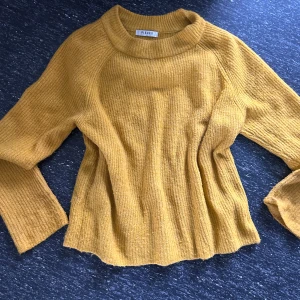 Gul stickad tröja från Pieces - Mysig gul stickad tröja från Pieces med rund halsringning och långa ärmar. Tröjan har en avslappnad passform och ribbade detaljer vid halsen och ärmsluten. Perfekt för lager-på-lager under kyliga dagar.