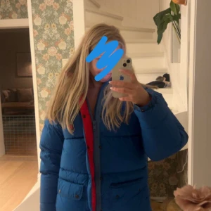 Blå dunjacka från Fjällräven - Säljer en blå dunjacka från Fjällräven med röd insida och huva. Storlek xxs, inga fläckar eller skador 💕