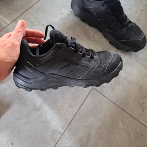 Svarta Adidas Terrex sneakers Gore-Tex - Säljer ett par svarta Adidas Terrex sneakers med robust sula och snörning. Skorna är tillverkade i slitstark syntet och mesh, och har Gore-Tex-membran som gör dem vattentäta. Perfekta för utomhusaktiviteter och äventyr.