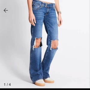Los waist jeans med slitna knän - Snygga blå jeans med stora slitningar över knäna. Jeansen har klassisk femficksdesign, lågmidjade och är tillverkade i jeansmaterial. Perfekta för dig som gillar en avslappnad och trendig look. Säljs oanvända med prislapp kvar.