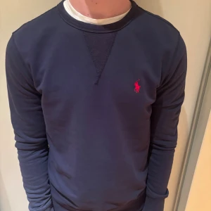 Ralph lauren tröja mörklblå Stl M - Mörkblå tröja från polo Ralph lauren. Storlek M och passar allt runt 180 cm. Vid funderingar är det bara att fråga!