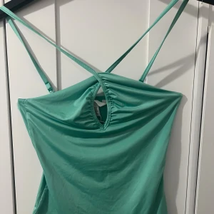 Grön body top med snygg cut-out - Super söt grön Body top från H&M i storlek XS. Halter style, använd 1 gång 