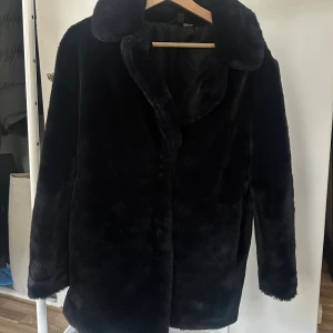 Svart pälsjacka med krage - Mysig svart pälsjacka med bred krage och lång ärm. Jackan har en klassisk rak passform och är tillverkad i mjukt fuskpälsmaterial!!! Från h&m i storlek S! Denna är sjukt len och så skönt att bära😍