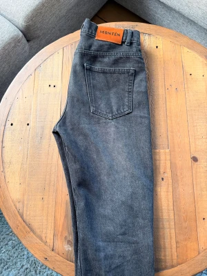 Svarta jeans från Montén - Ett par extremt snygga skräddarsydda jeans från Montén som inte längre går att få tag i! Passformen är rak med en otroligt fet tvätt. Storlek W30 L29 ish. Hör av dig vid frågor och funderingar! Mhv katten ingår inte🤗