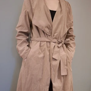 Beige kappa - Tunn beige kappa, passar till sommar höst och vår. Lite vrinkor men går enkelt att stryka/steama bort. Inga tydliga defekter. Används några få gånger. Nypris ca 400-500 kr. Hund och katt finns i hemmet. Skickas via instabox/postnord.