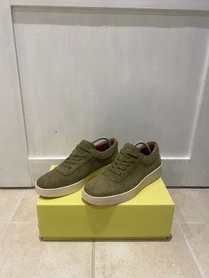 J.Lindeberg Sneakers  - Tja! Säljer dessa riktigt snygga J.Lindeberg Seakers för endast 799kr. Endast använda 3 gånger, då de därför den har smutsig undersula. En liten defekt på innersulan på vänster skon! | Nypris - 2400kr | Skick - 9/10 | Size - 41 | Medföljer - Og Box | Tveka inte att höra av dig vid minsta lilla fundering!🙌