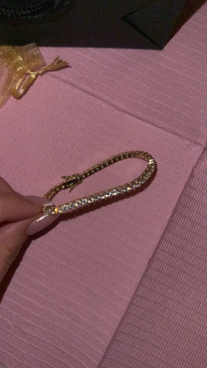 Glittrigt guldarmband med stenar - Snygg armband i guldton med glittrande stenar längs hela bandet. Oanvänd‼️blir inte rostig (guldplaterad)