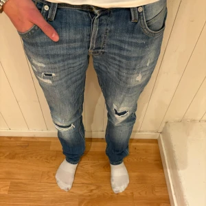 Blå slitna jeans från jack&jones  - Säljer ett par blå jack&jones jeans i modellen slim/glenn. Dessa har en cool design och jag säljer endast för 249kr! Fynda snabbt innan det är försent och kontakta för frågor eller förslag!