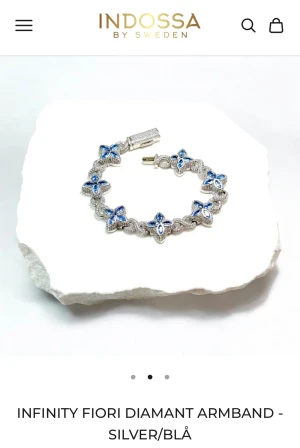 Infinity Fiori diamantarmband silver/blå - Ett armband i silverfärg från Indossa by Sweden, dekorerat med blå blommor. Ord pris: armband + ask 2000kr💗 i ny skick