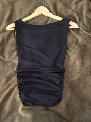 Topp från Gina Tricot - Marinblå topp från Gina med sömmar på sidorna så den sitter tajt o formar kroppsformen