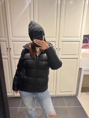 Svart pufferjacka från Everest (liten i storleken!) - Säljer en svart pufferjacka från Everest med huva och dragkedja framtill. Nypris 2500kr. Liten i storleken! Knappt använd!