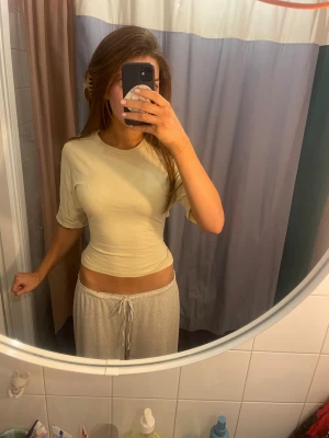 Gul omlottopp med knyt/rosett bak från Nelly - Säljer en gul topp med rosett bak från Nelly i storlek XS. Toppen har korta ärmar, rund hals och öppen rygg med snygg knytning bak. Materialet känns mjukt och lätt, perfekt för varmare dagar. Enkel och stilren design som är lätt att matcha.