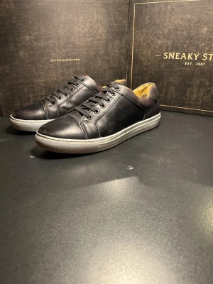 Svarta sneakers från Steptronic - Snygga svarta sneakers från Steptronic med klassisk rund tå och platt vit sula. Skorna är tillverkade i skinn och har svarta snören samt en diskret design som passar till många stilar. Insidan är beige och ger en schysst kontrast mot det svarta yttermaterialet.
