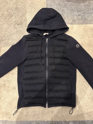Moncler Cardigan  - Allmänt bra skick, har två skador på bröstet på ca 1 cm som sytts ihop och knappt märks