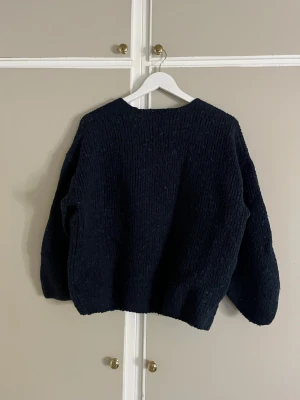 Mörkblå stickad kofta från Lindex - Mysig mörkblå stickad kofta från Lindex i storlek M/L. Koftan har en öppen front utan knappar och långa ärmar med loose passform. Perfekt för att slänga över en t-shirt när det är kyligt ute. Enkel och stilren design som funkar till många olika looks.