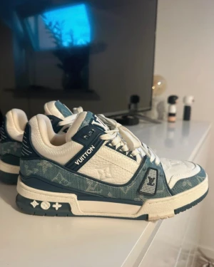 Louis Vuitton blåvita sneakers - Riktigt snygga Louis Vuitton sneakers, Skick: Nya, aldrig använda. Storlek 42 snabb och noggrann frakt! Perfekta för dig som gillar exklusiv streetstyle. Pris kan diskuteras! 